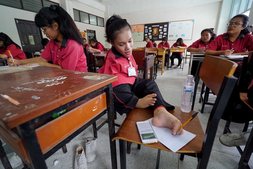 Fai studies among her classmates at school.