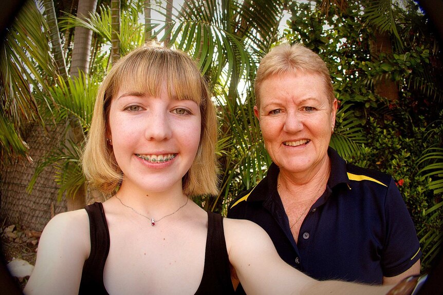 Girl and her mum taking a selfie in the garden. Smiling.