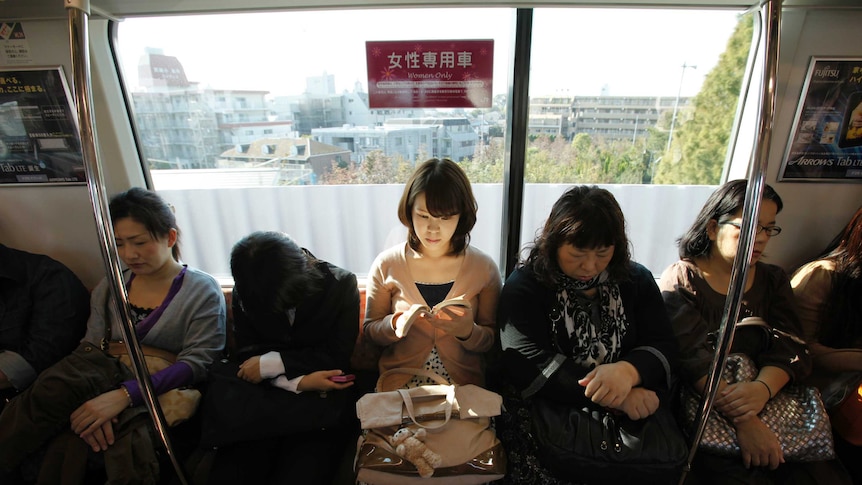 A woman sits in a women's only passenger carriage on the tokyo subway.