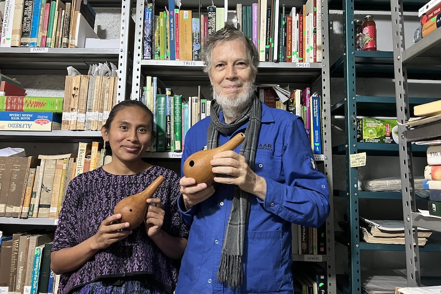 Two researchers hold recently discovered enema syringes from Guatemala