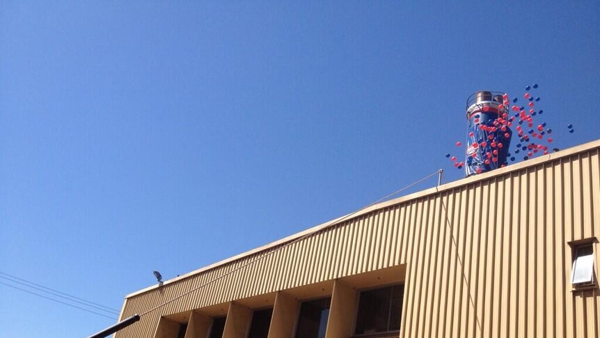 The covers come off the chimney of the brewery to reveal the colours of premiership-winning Norwood.