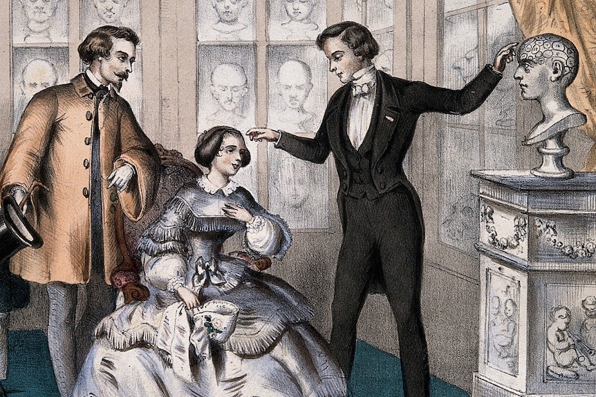 An 1800s colour illustration of a man inspecting a woman's head, as another man looks on, surrounded by plaster heads