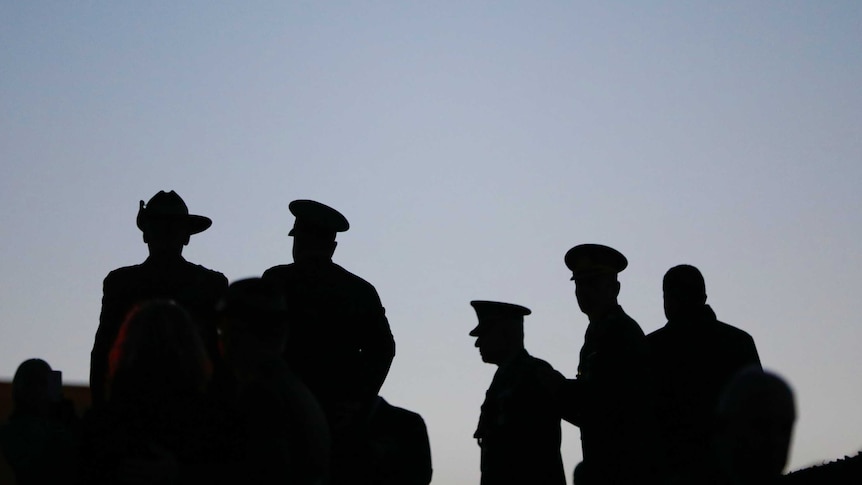 Silhouettes of military personnel at the national Anzac Day dawn service