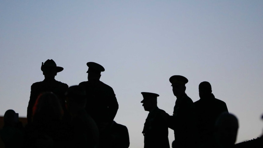 Silhouettes of military personnel at the national Anzac Day dawn service