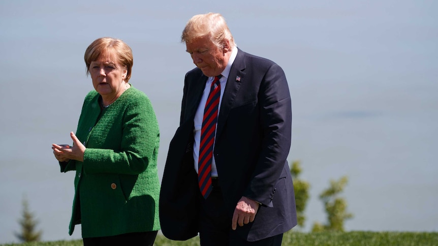 Donald Trump talks with Angela Merkel.