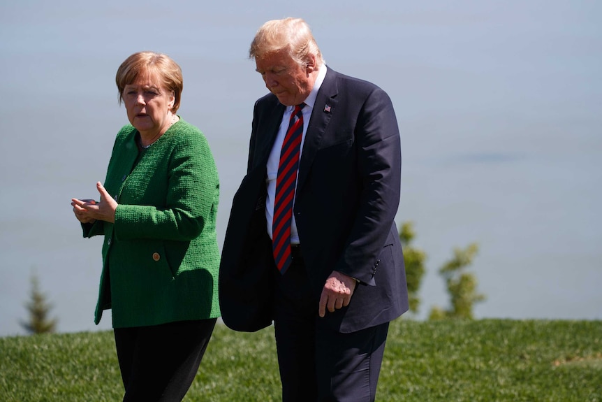 Donald Trump talks with Angela Merkel.