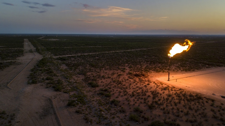 A flaring gas well in arid land.