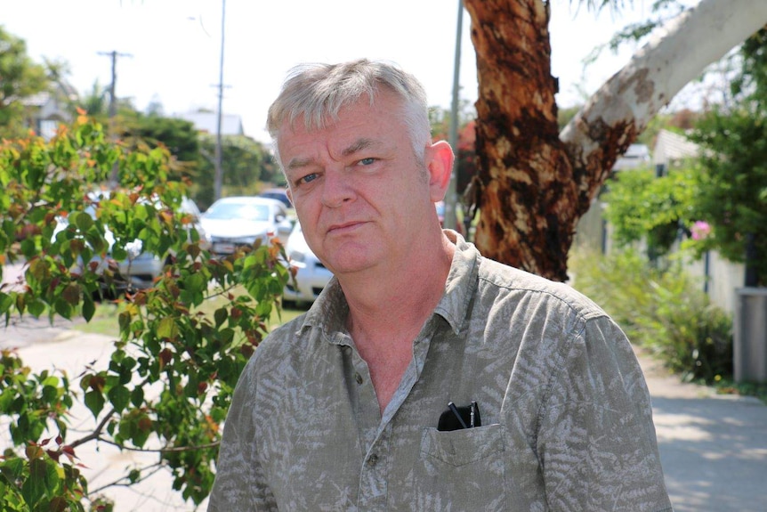 Robin Stevens standing in front of a tree in a driveway.