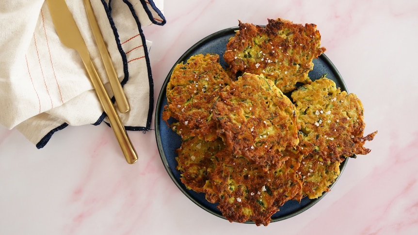 A plate of zucchini fritters sprinkled with sea salt, an easy way to use up excess zucchini and fill lunch boxes.