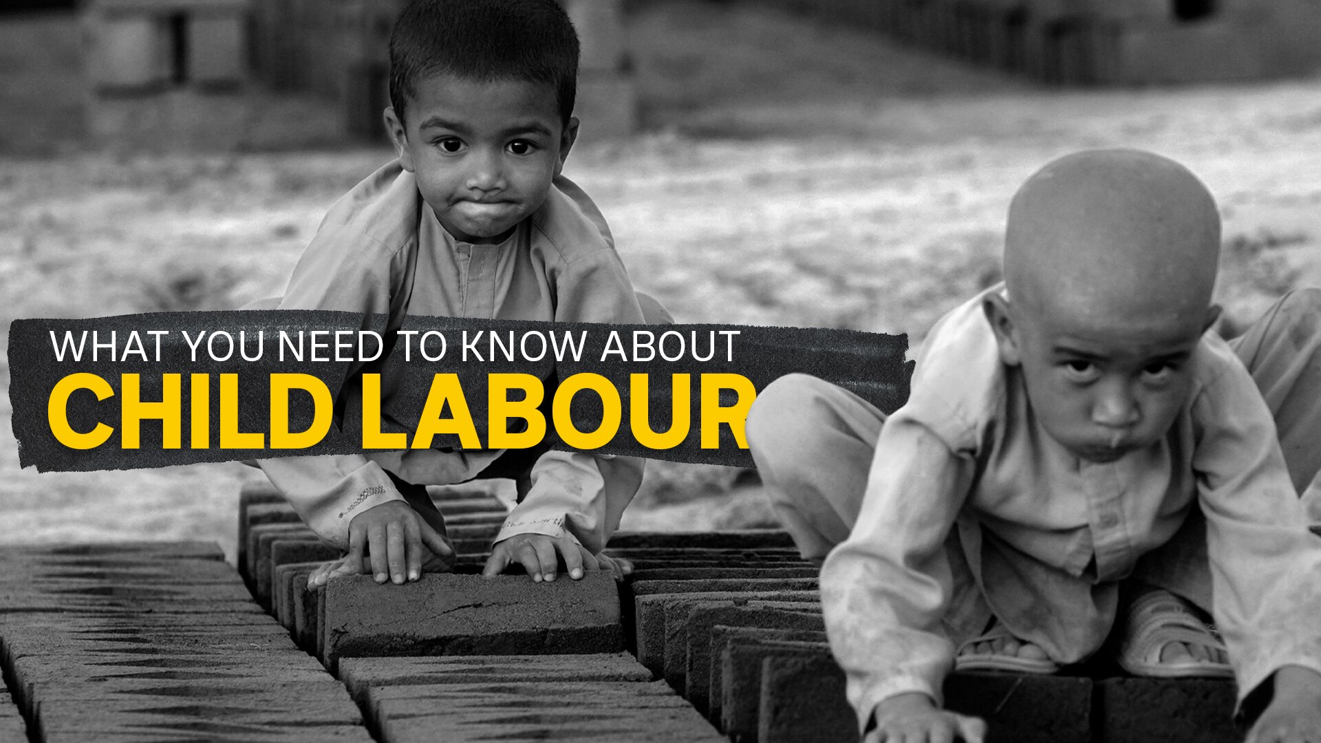Two children work on turning over rows of bricks one at a time.