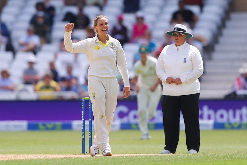 Australia's Ash Gardner smiles and raises her hands above her head in triumph after taking a wicket in a Women's Ashes Test.