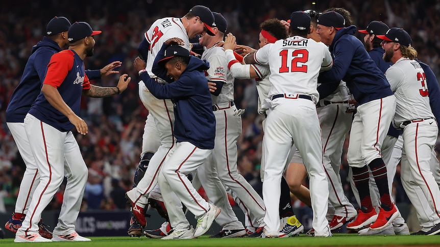 Atlanta Braves baseball players embrace as they celebrate reaching the World Series.
