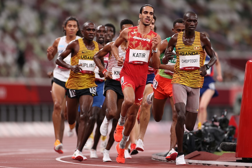 A group of men in tights run next to each other on a track