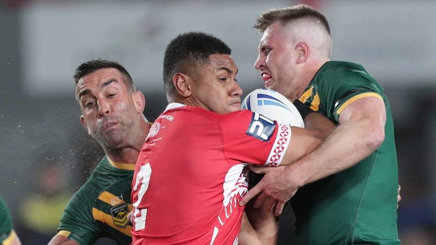 David Fusitu'a of Tonga runs into the tackle of Australia's Cameron Munster and Paul Vaughan.