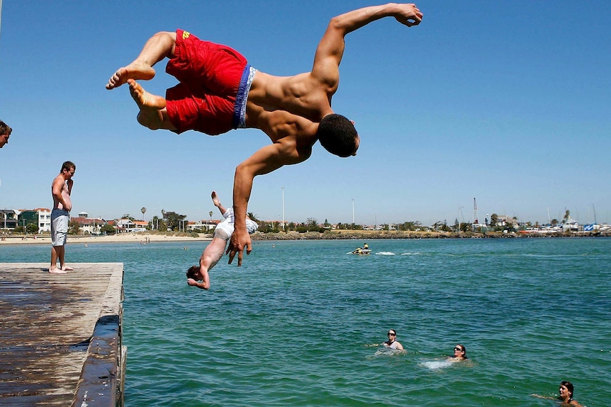 People jump of a pier during a heatwave