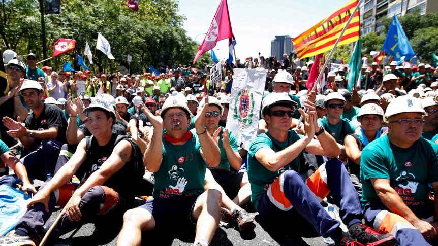 Spanish Miners clap as they sit on a street in Madrid protesting against austerity measures.