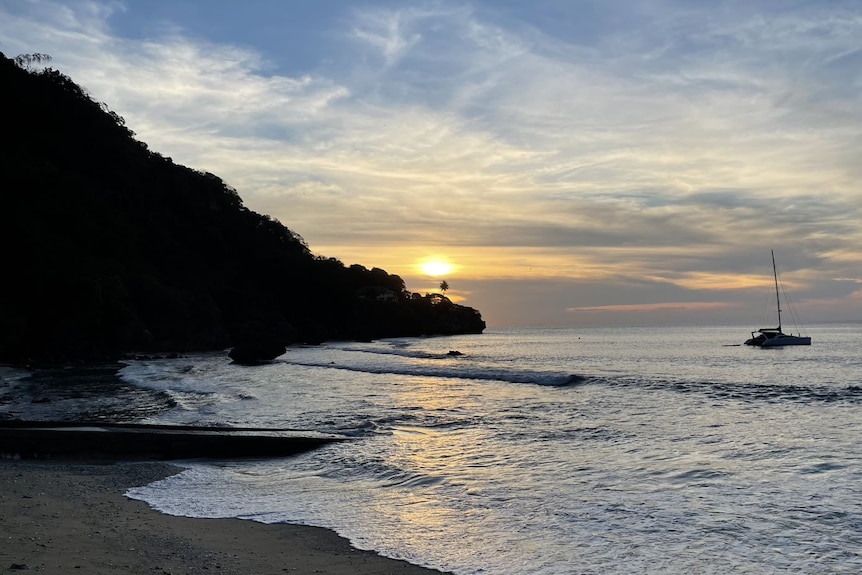 A boat sits in water off a beach at Christmas Island.