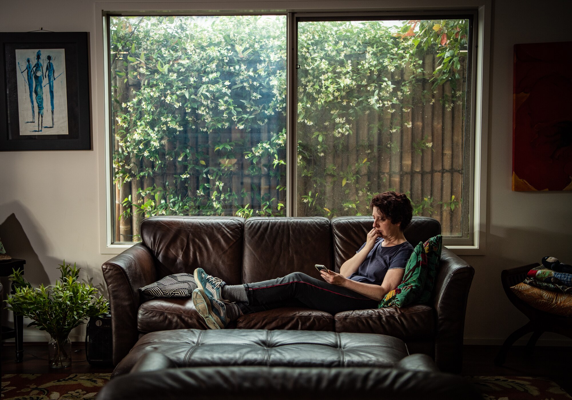 A woman laying down on a couch looking pensive