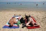 Two men sunbaking on a beach