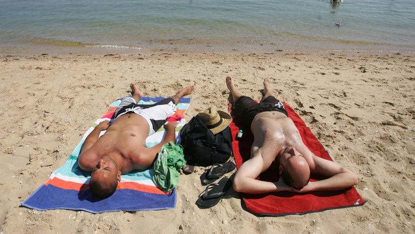 Two men sunbaking on a beach