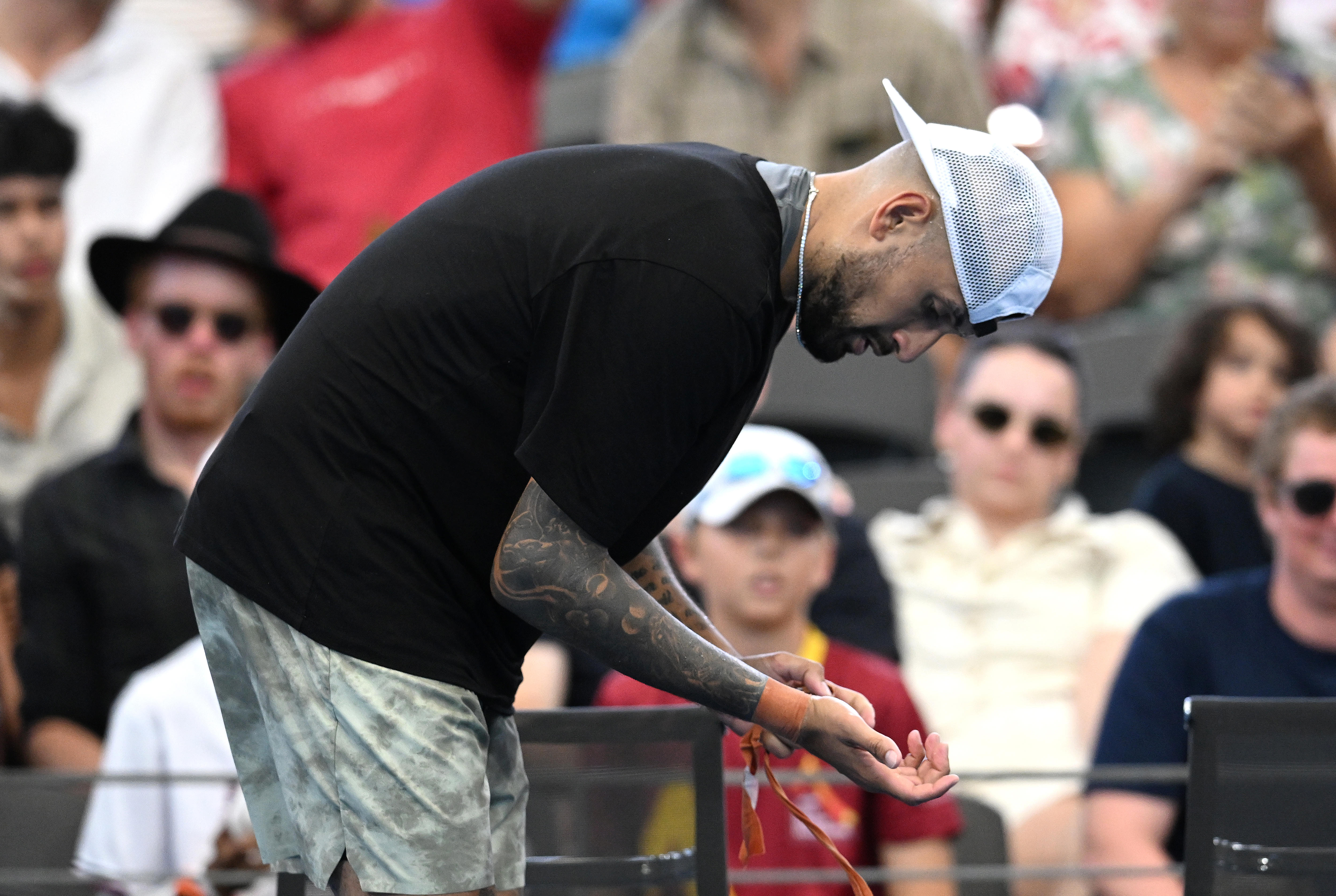 Nick Kyrgios mira la correa de su muñeca