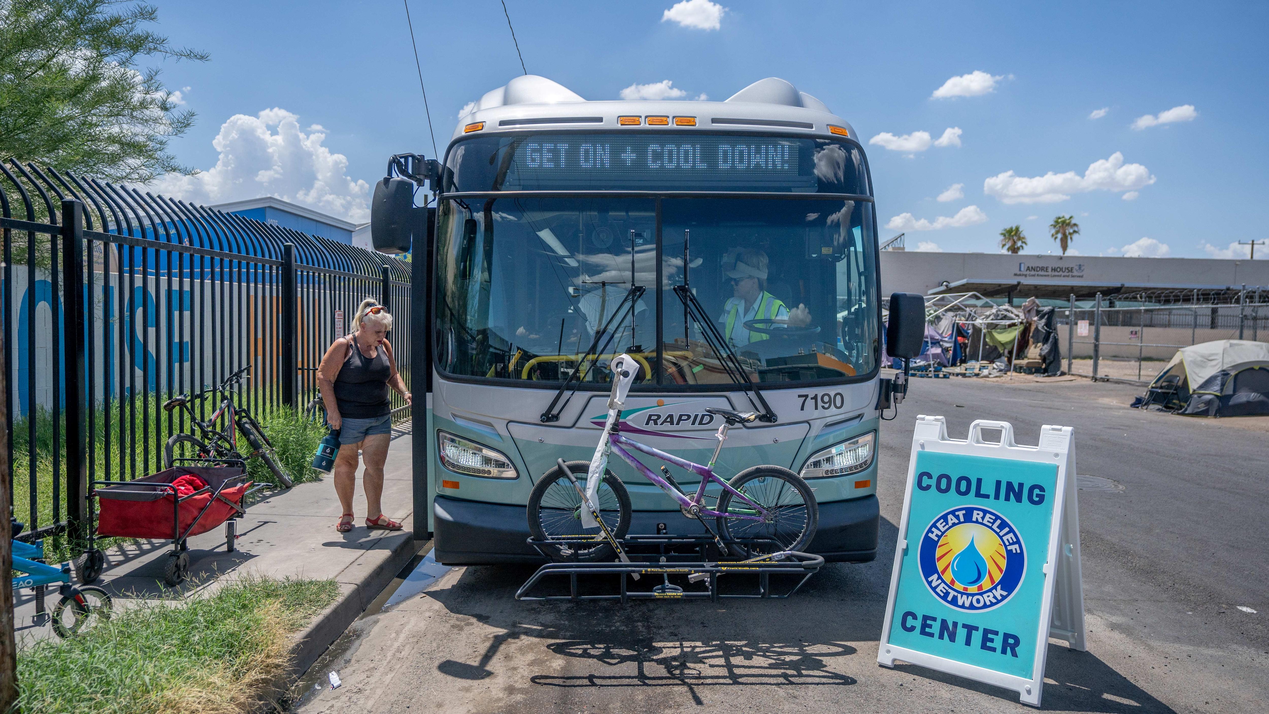 A woman steps onto a bus that has been transformed into a cooling station.