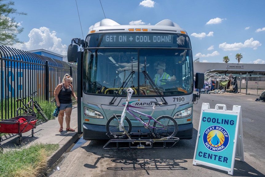 A woman steps onto a bus that has been transformed into a cooling station.