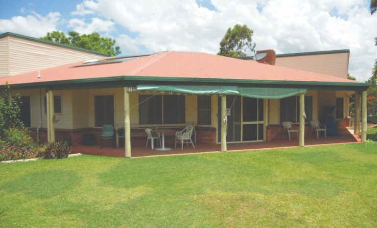 A cottage in front of green grass