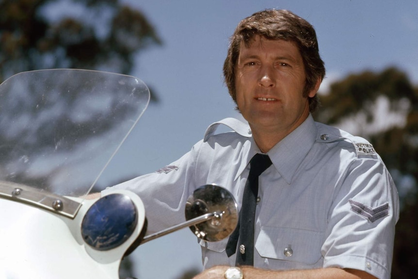 Actor Paul Cronin in police uniform on a motorbike in a scene from Matlock Police.