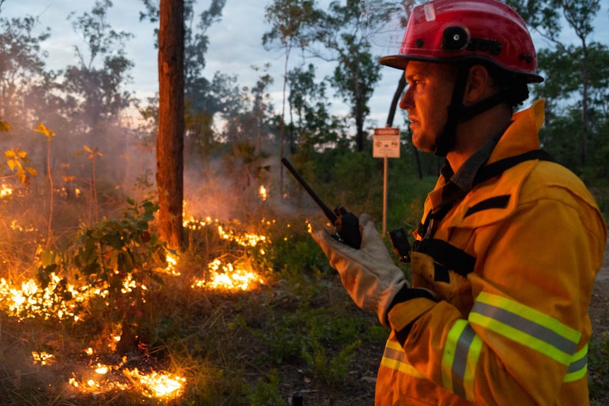 A firefighter speaks on a radio