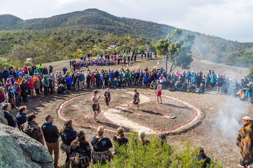 Spectators in a large circle watch the Wadawurrung ceremony.