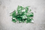 A smashed green glass bottle on concrete