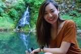 美国华人教师钟珺骅蹲在一团池水旁。