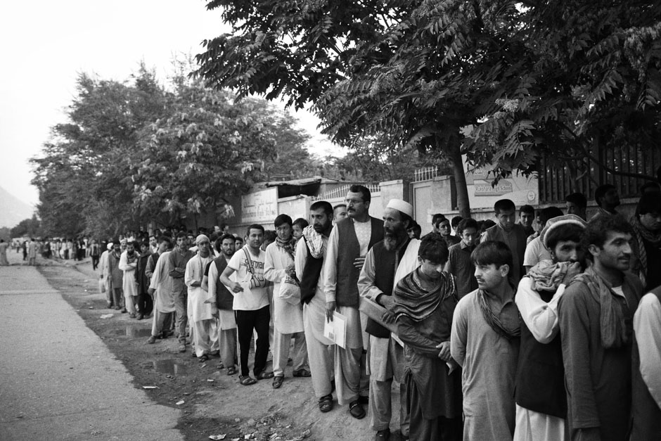 Documents in hand, hundreds of Afghan passport applicants queue before sunrise outside Afghanistan's only passport office.