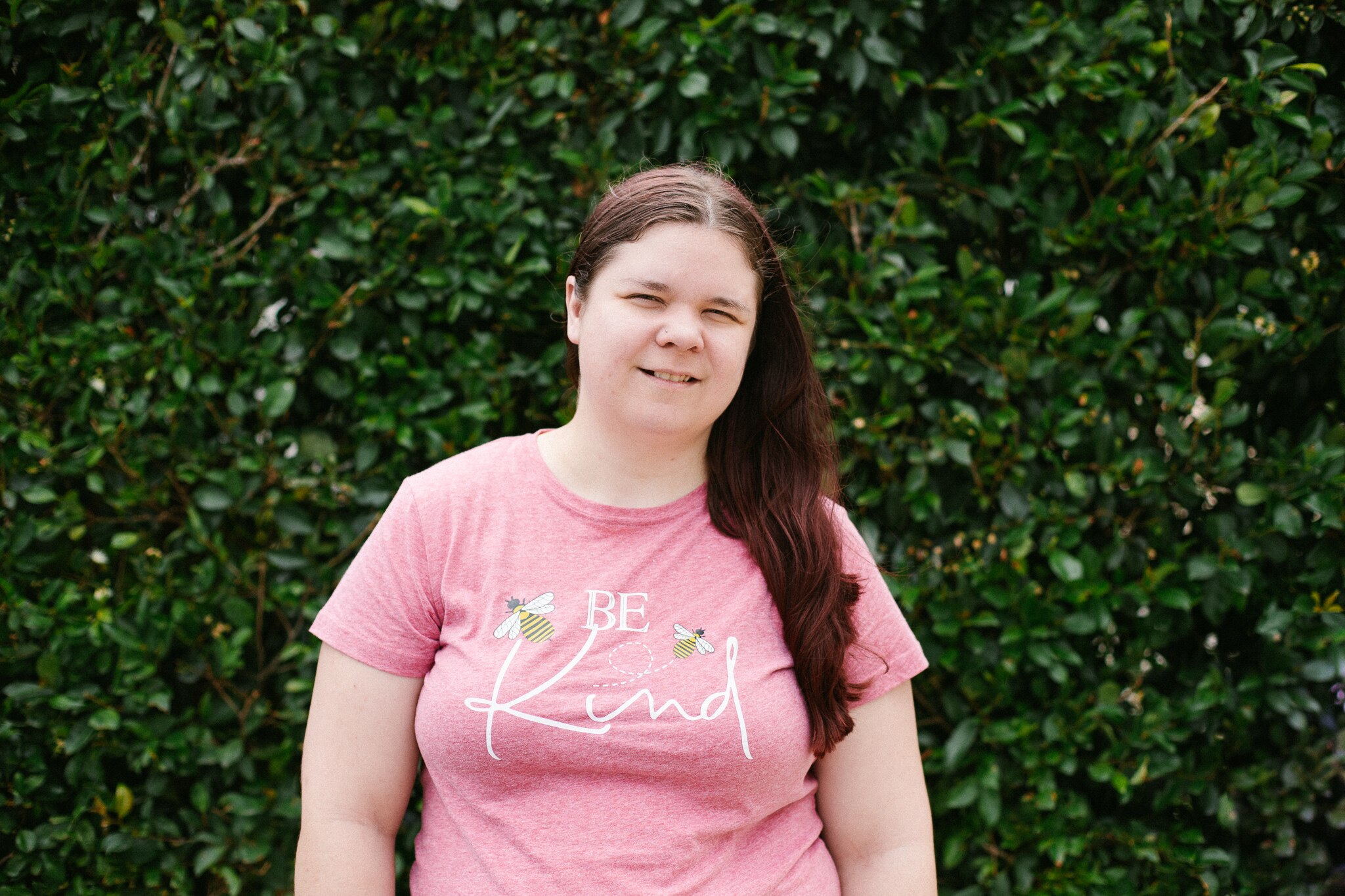 Tasha Torzsa smiles while wearing a t-shirt with the words "Be Kind".