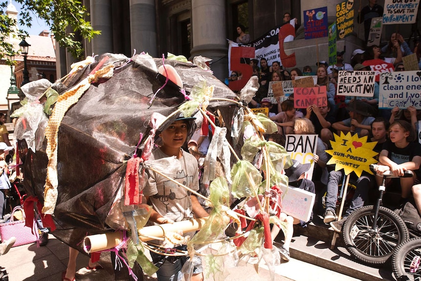A student climate inaction protester with his fish model