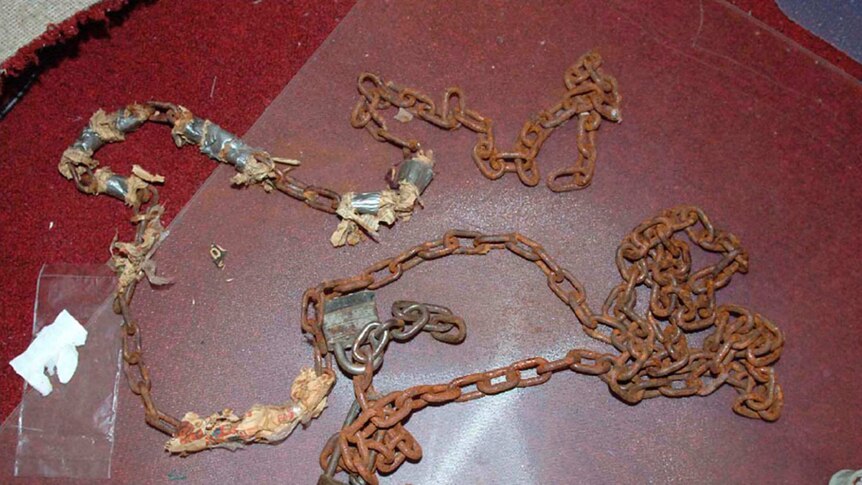 Rusty locks and chains sit on the floor of a room in Ariel Castro's house