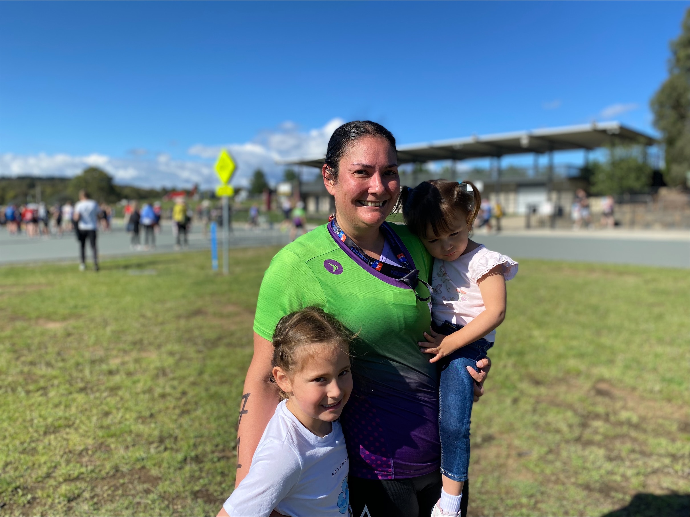 A woman in a triathlon suit with her two young daughters