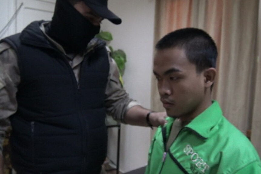 An Indonesian man who travelled to Syria to join IS is escorted into a counter-terrorism office.