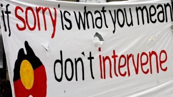 A banner at a rally calls for an end to the Northern Territory intervention.