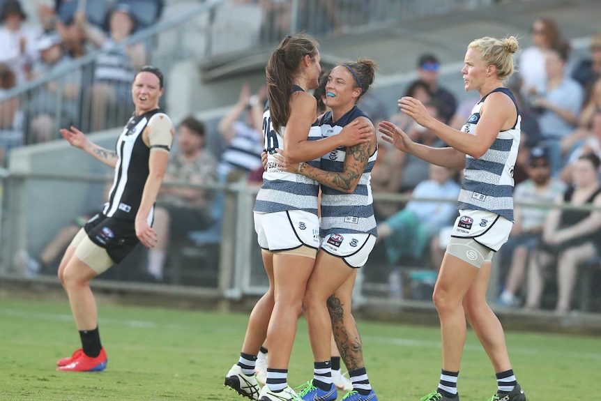 Geelong players celebrate an AFLW goal against Collingwood.