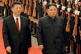 Kim Jong-un and Xi Jinping inspect honour guards in Beijing, they are walking in a hall.