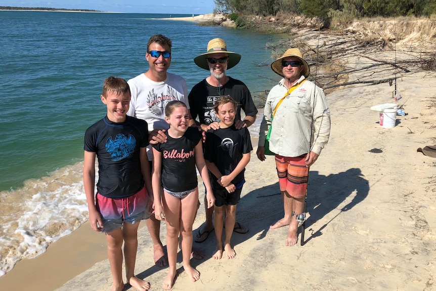 A group of swimmers and fishermen standing at Inskip beach.