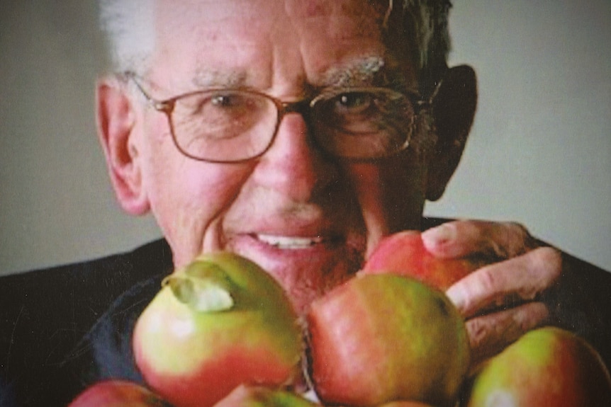 A man holding apples.