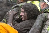 Emergency personnel carry a woman rescued from a collapsed house after a mudslide in Montecito