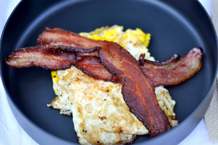 Bacon and eggs in a pan.