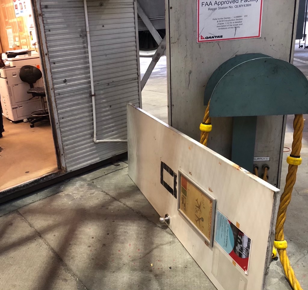 A door off its hinges in a Qantas maintenance area