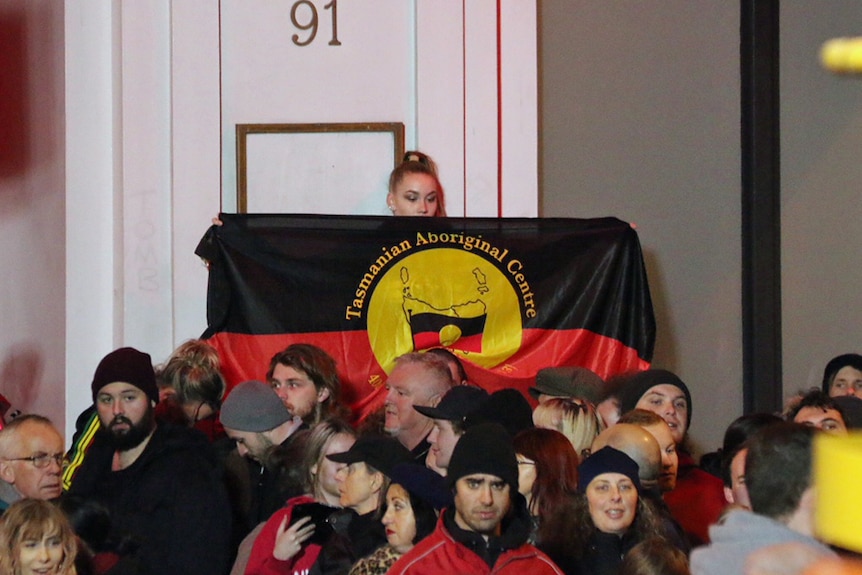 Aboriginal flag held at the Mike Parr performance