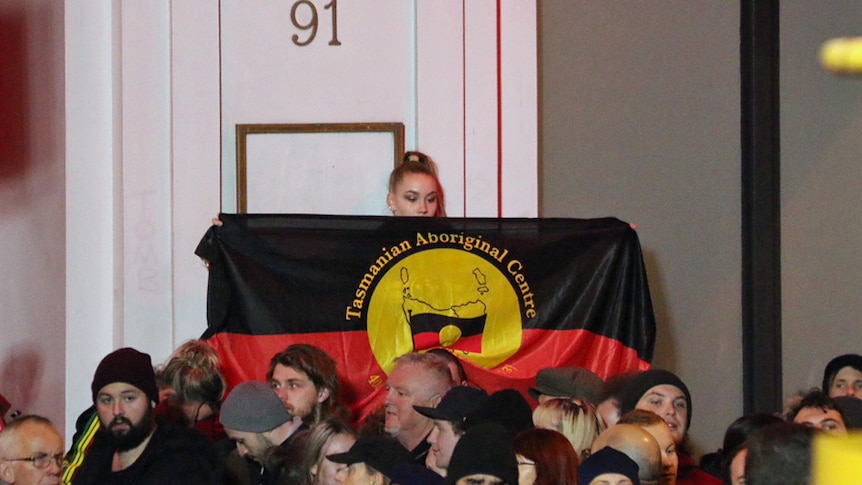 Aboriginal flag held at the Mike Parr performance