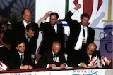 Men in suits celebrate winning the Sydney Olympic bid.